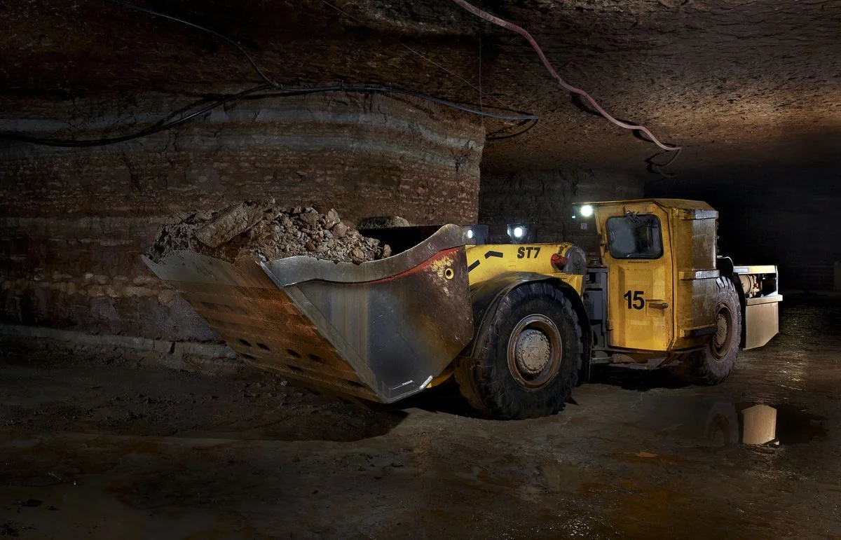 Underground loader hauling ore in a mine drift